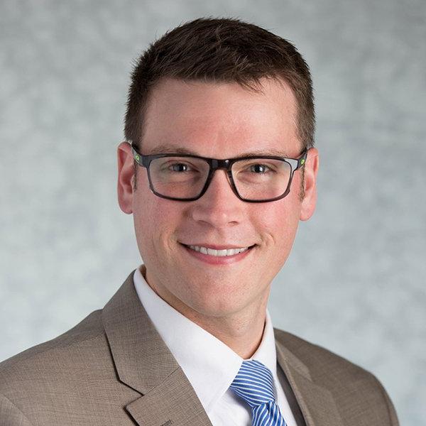 Kris Pachla smiles in a posed studio portrait.