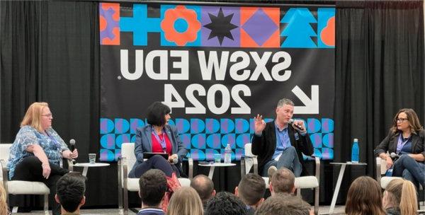 President Mantella sits on stage between other panelists. A colorful banner behind her reads SXSW EDU 2024.